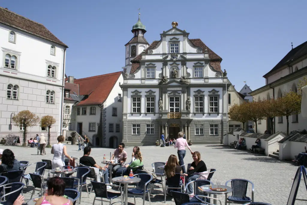 Ihr seht den Marktplatz vor dem Rathaus in Wangen mit einem Café. JUFA Hotels bietet erholsamen Familienurlaub und einen unvergesslichen Winter- und Wanderurlaub.