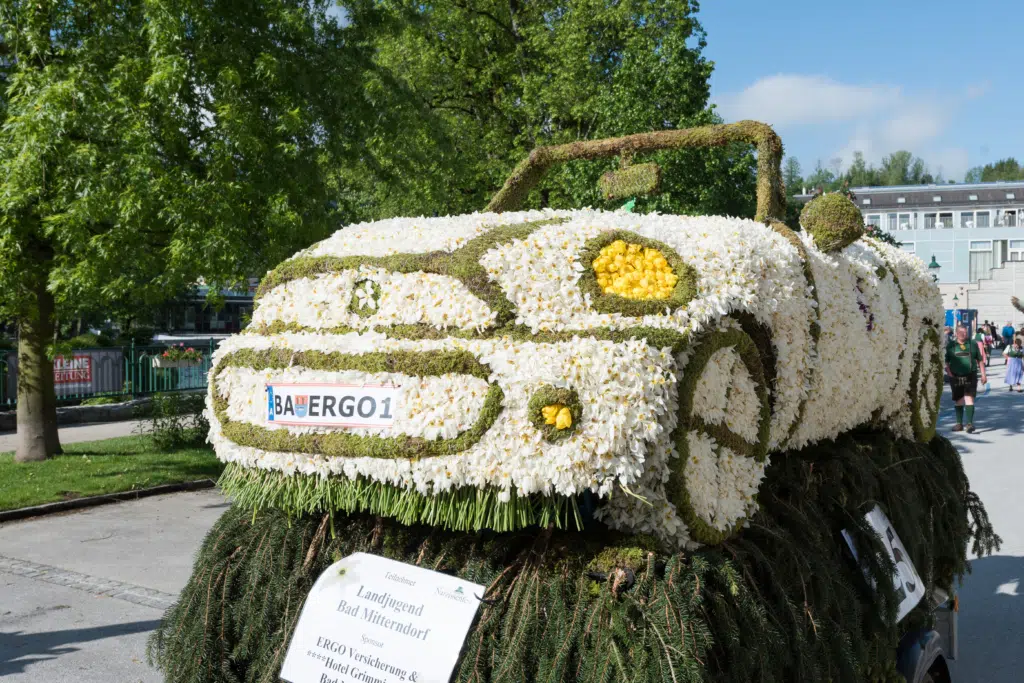 Ihr seht eine Autoblumenfigur während des Stadtkorso in Bad Aussee. JUFA Hotels bietet kinderfreundlichen und erlebnisreichen Urlaub für die ganze Familie.