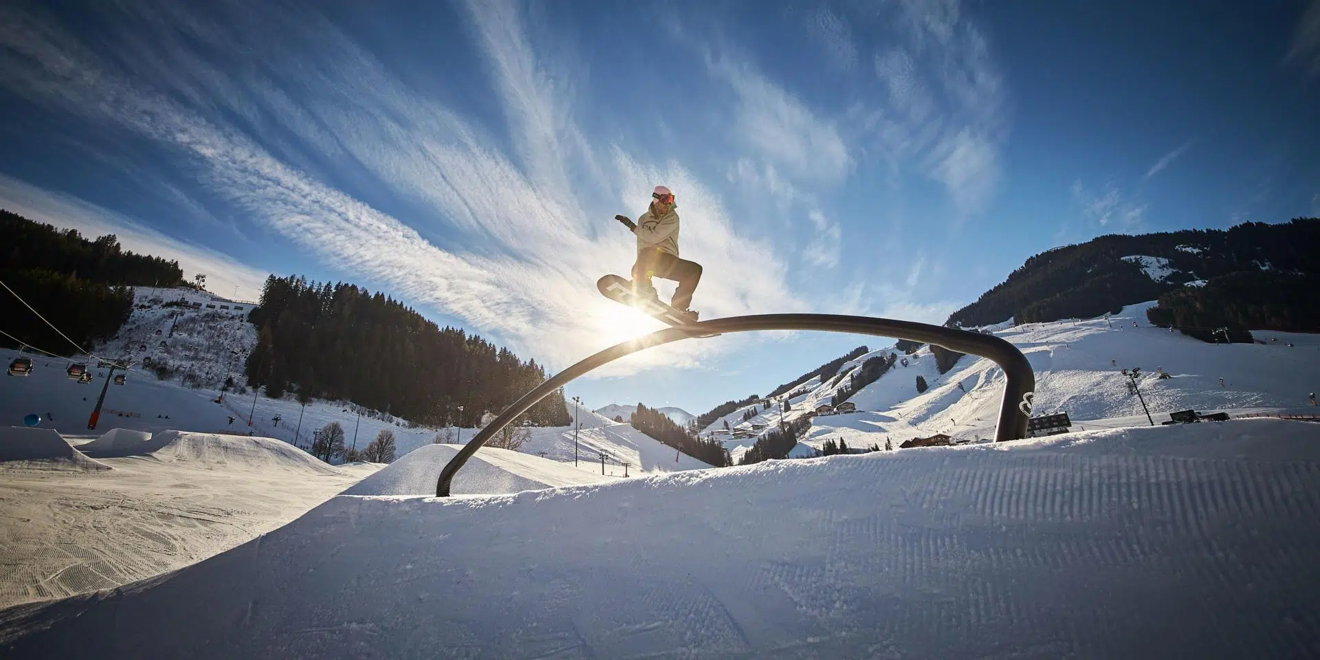 Sie sehen einen Skifahrer im Nightpark in Saalbach auf einem Hindernis. JUFA Hotels bietet kinderfreundlichen und erlebnisreichen Urlaub für die ganze Familie.