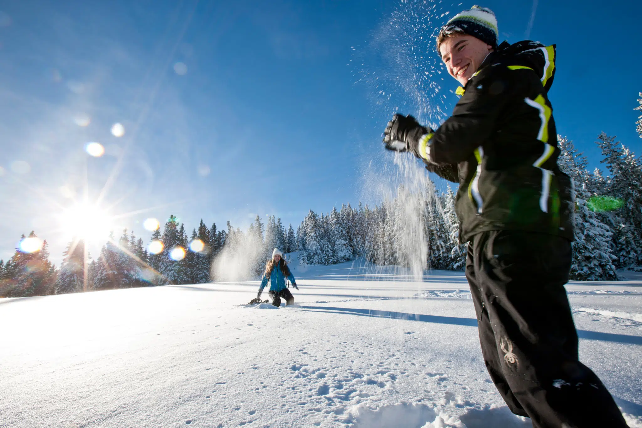 Paar bei einer Schneeballschlacht im Skigebiet Salzstiegl