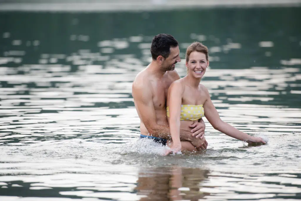 Ihr seht ein Paar im Stubenbergsee im Sommer. JUFA Hotels bietet tollen Sommerurlaub an schönen Seen für die ganze Familie.