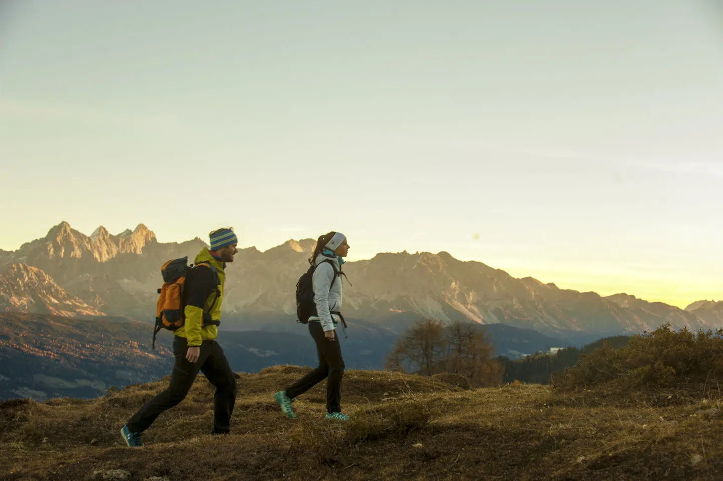 Ihr seht ein Paar bei einer Sonnenaufgangswanderung in den Bergen des Salzburger Lands. JUFA Hotels bietet erholsamen Familienurlaub und einen unvergesslichen Winter- und Wanderurlaub.