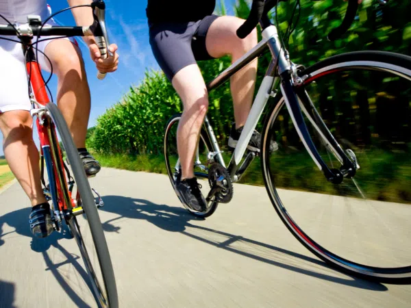 Ihr seht die Beine von Personen beim Radfahren.