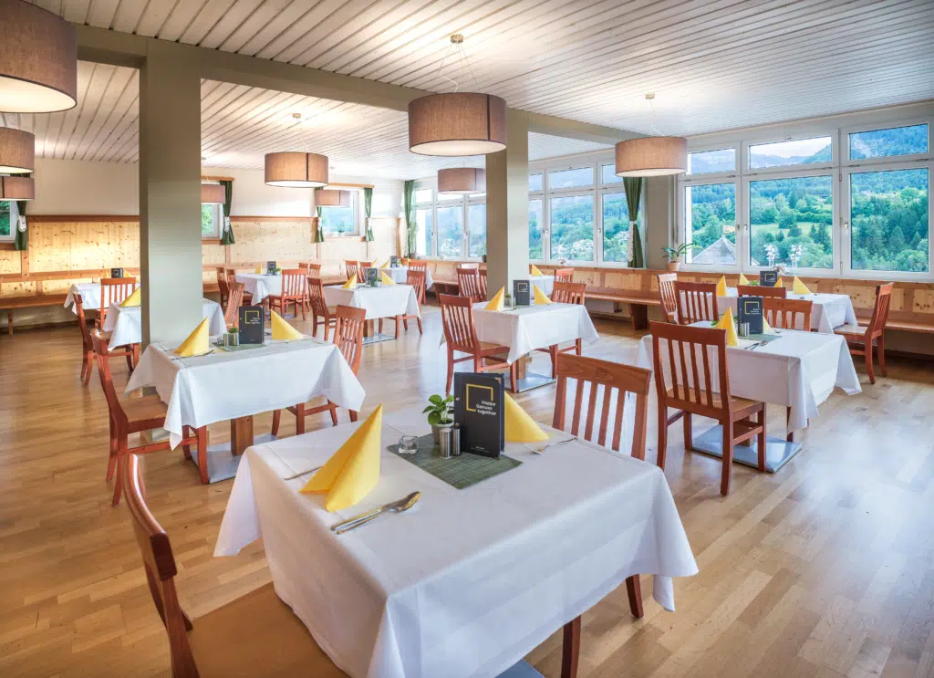 Ihr seht die Sitzbereiche im Restaurant und Frühstücksbereich im JUFA Hotel Bad Aussee***. Der Ort für tollen Sommerurlaub an schönen Seen für die ganze Familie.