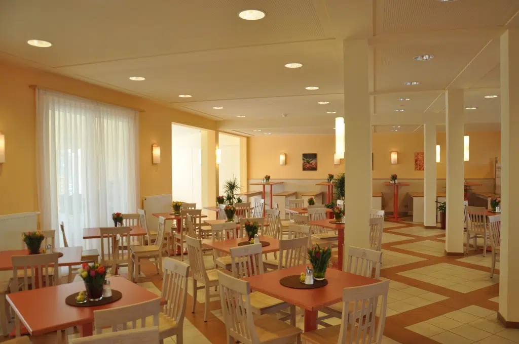 Ihr seht ein gemütliches Restaurant mit Tulpenstrauß auf den Tischen im JUFA Hotel Jülich***s. Der Ort für kinderfreundlichen und erlebnisreichen Urlaub für die ganze Familie.