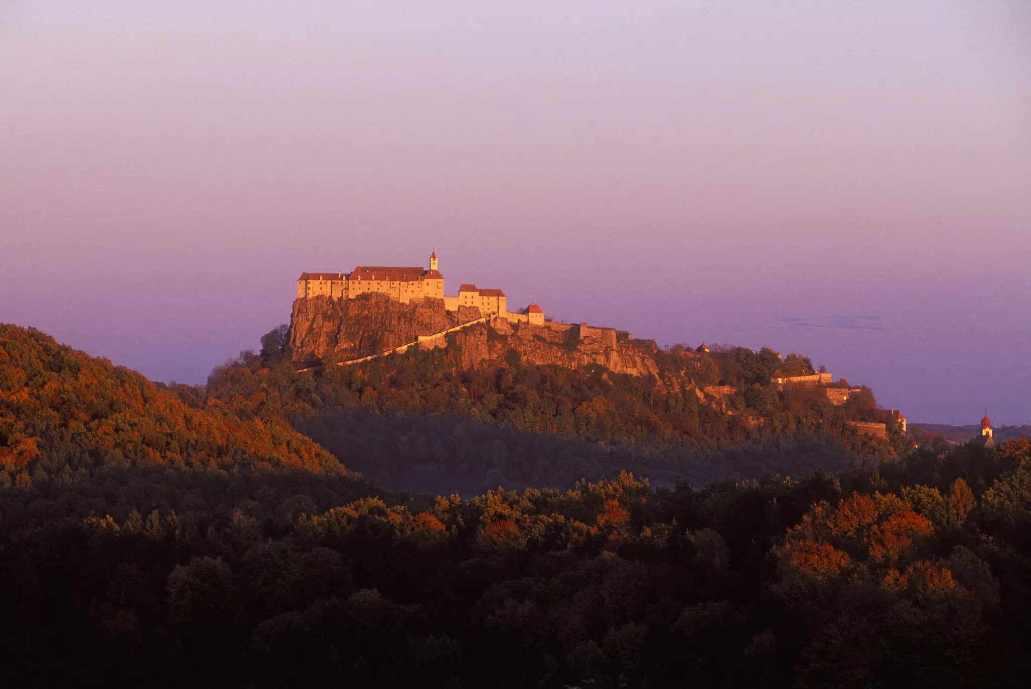 Riegersburg mit Abendstimmung in der Steiermark in der Nähe von JUFA Hotels. Der Ort für erholsamen Familienurlaub und einen unvergesslichen Winter- und Wanderurlaub.