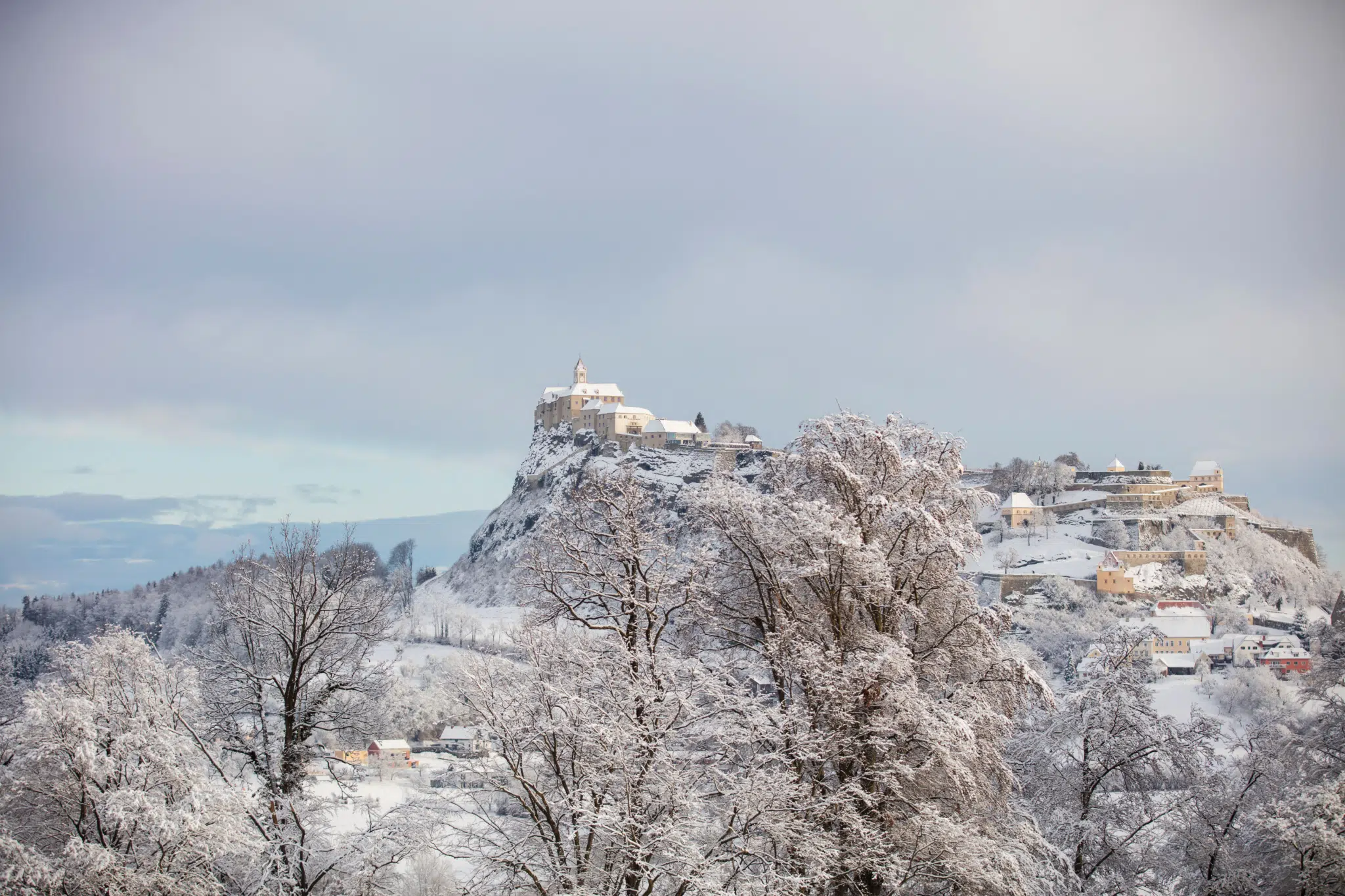 Ihr seht ein Bild von der Riegersburg im steirischen Thermen- & Vulkanland im Winter mit der umliegenden Region im Hintergrund.