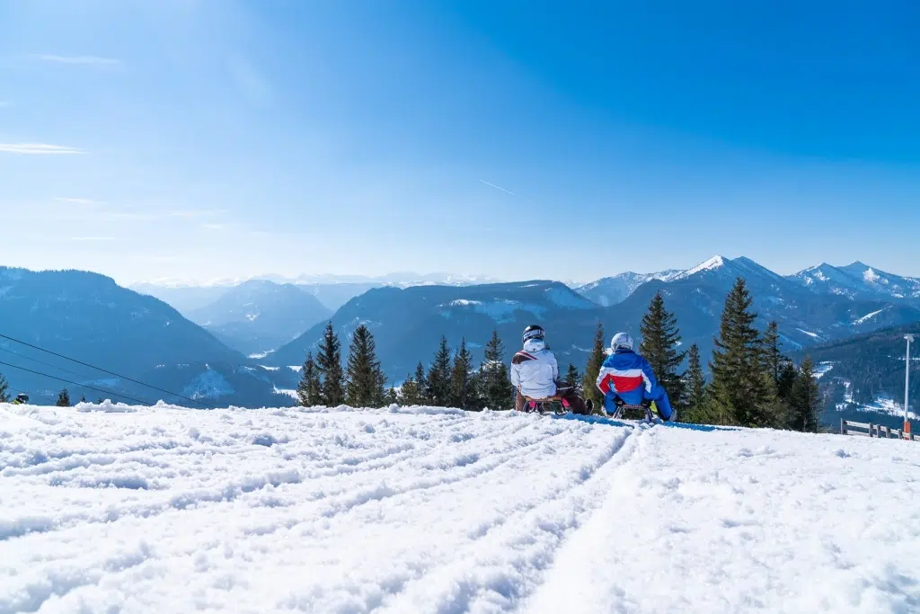 Ihr seht zwei Personen beim Rodeln auf der Bürgeralpe im Mariazeller Land.