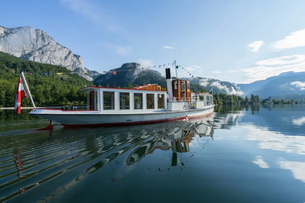 Ihr seht ein Schiff am Grundlsee. JUFA Hotels bietet tollen Sommerurlaub an schönen Seen für die ganze Familie.