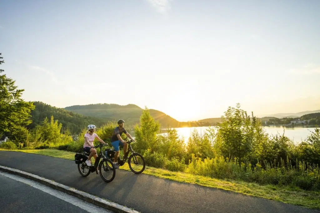 Ihr seht zwei Personen beim Radfahren entlang der Seenschleife am Klopeiner See.