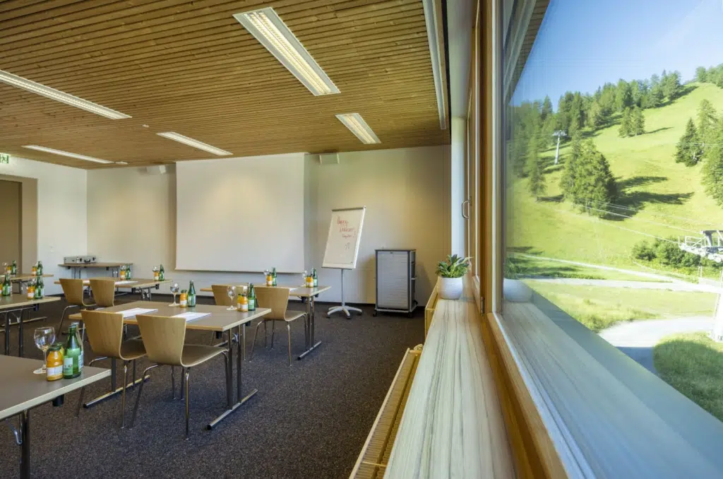 Sie sehen einen Seminarraum im JUFA Hotel Malbun mit Aussicht auf die Alm.