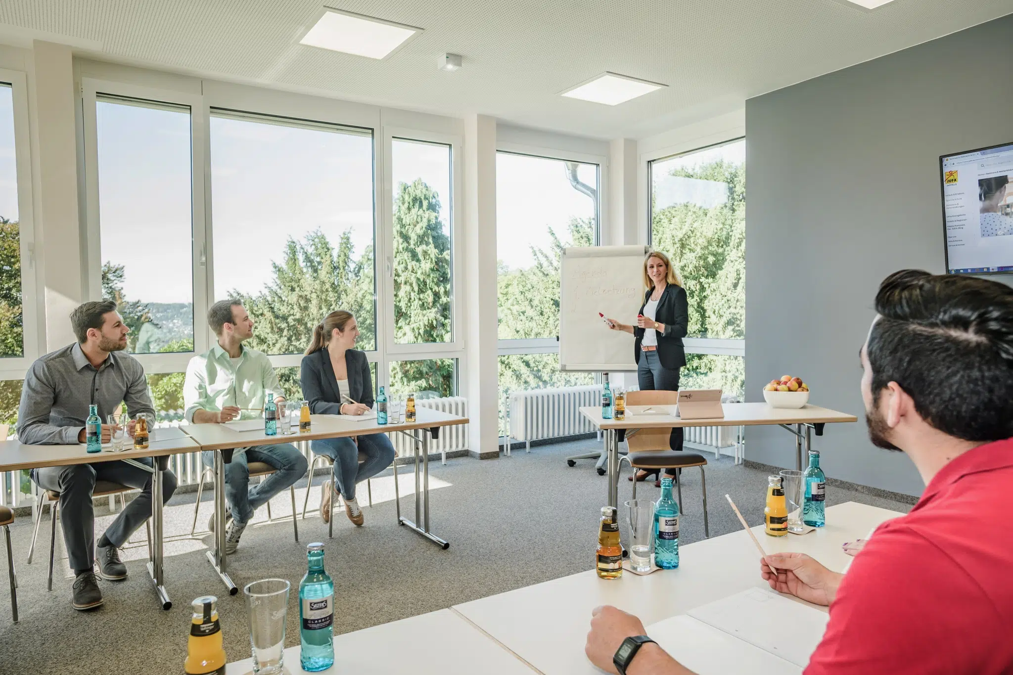 Ihr seht den Seminarraum im JUFA Hotel Königswinter**** mit einem Vortrag. JUFA Hotels bietet erlebnisreichen Städtetrip für die ganze Familie und den idealen Platz für Ihr Seminar.