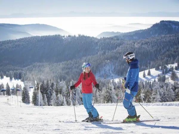 Ihr seht zwei Personen beim Skifahren am Feldberg im Schwarzwald.