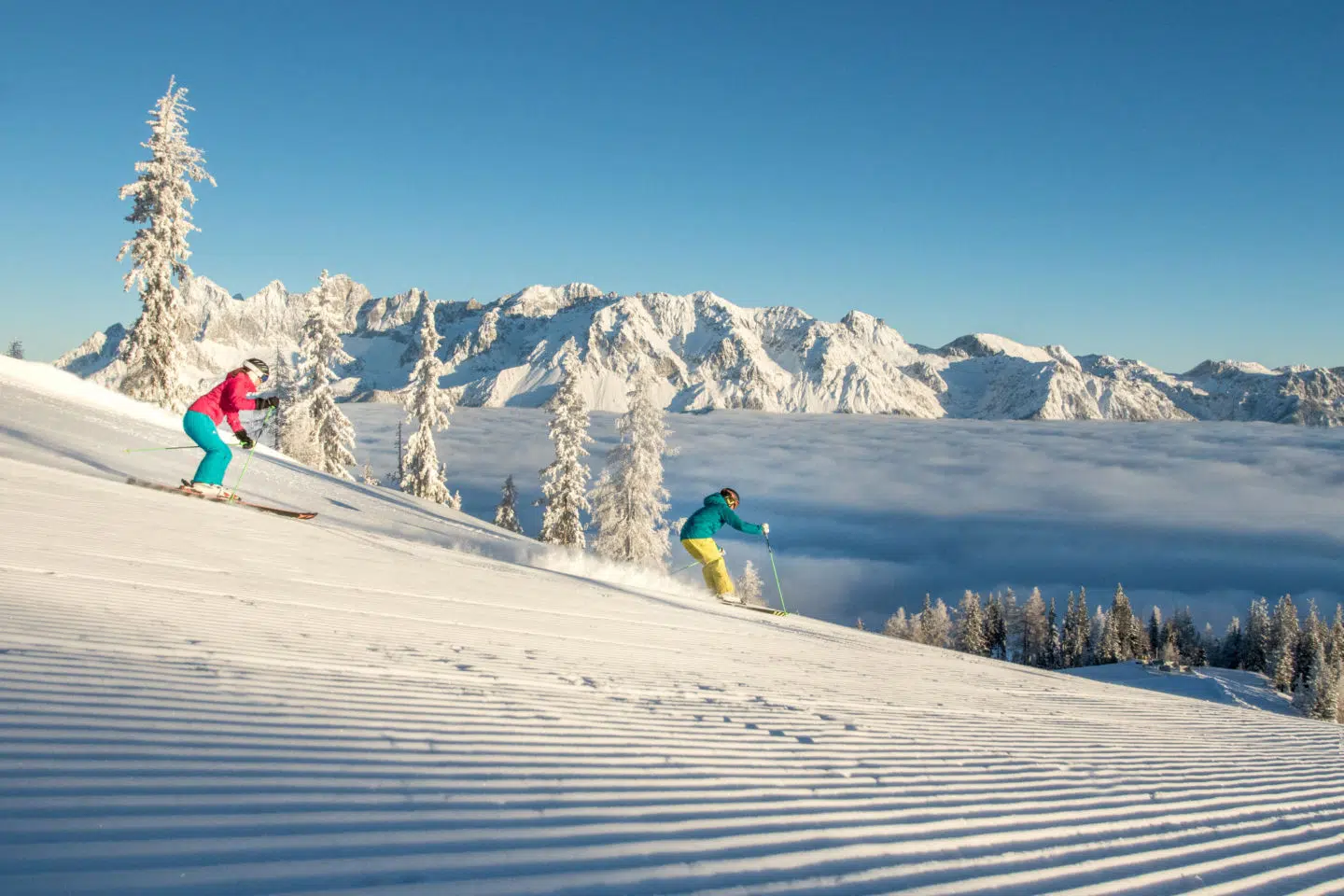 Ihr seht zwei Skifahrer am Hochwurzen in Schladming-Dachstein.