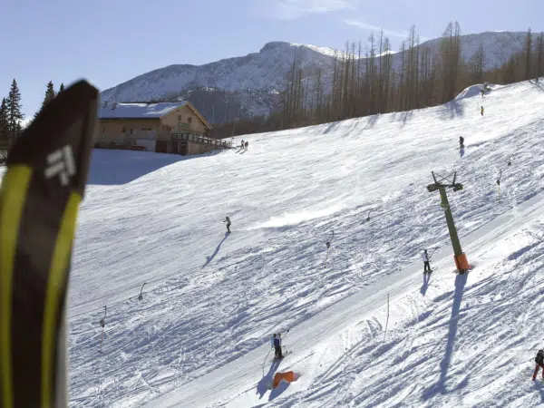 Skifahrer beim Skifahren auf der Piste im Skigebiet Petzen in der Nähe von JUFA Hotels. Der Ort für erholsamen Familienurlaub und einen unvergesslichen Winterurlaub.