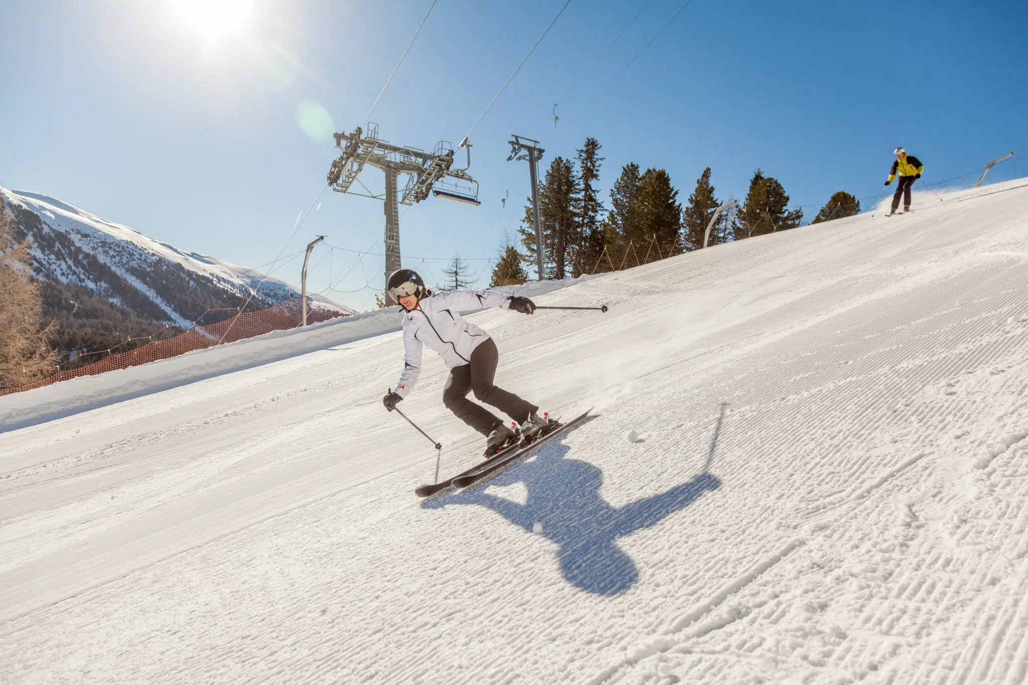 Eine Skifahrerin fährt gekonnt die bestens präparierte Piste im Skigebiet Turracher Höhe in Kärnten hinunter. JUFA Hotels bietet erholsamen Familienurlaub und einen unvergesslichen Winterurlaub.