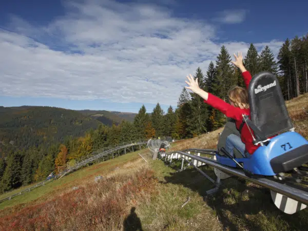 Ihr seht eine Frau beim Fahren der Sommerrodelbahn Hasenhorn Coaster in Todtnau.