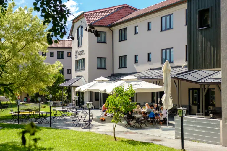 Ihr seht das JUFA Hotel Lipizzanerheimat von Aussen mit Garten und Spielplatz. JUFA Hotels bietet kinderfreundlichen und erlebnisreichen Urlaub für die ganze Familie.