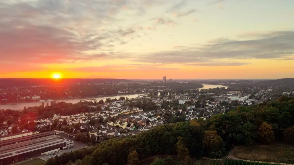 Ihr seht den Sonnenuntergang über Königswinter. JUFA Hotels bietet erholsamen Familienurlaub und einen unvergesslichen Winter- und Wanderurlaub.