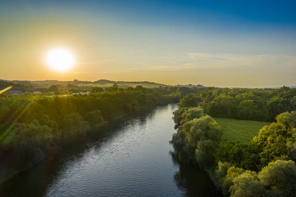 Ihr seht einen Sonnenuntergang über der Mur im UNESCO Biosphärenpark Amazon of Europe