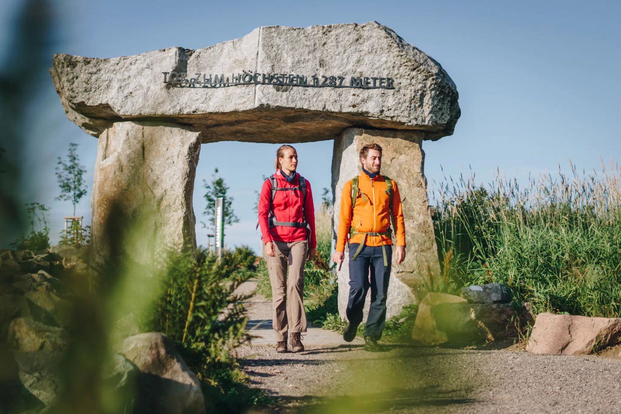 Ihr seht ein Pärchen, das durch das Westwegportal am Feldberg im Schwarzwald wandert. JUFA Hotels bietet Ihnen den Ort für erlebnisreichen Natururlaub für die ganze Familie.