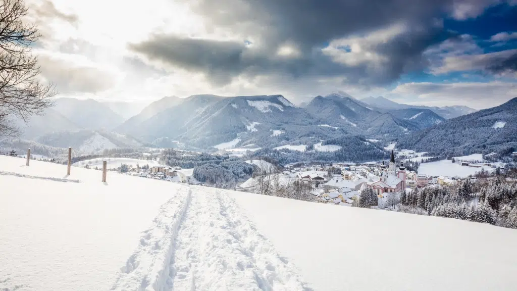 Ihr seht die verschneite Winterlandschaft im Mariazeller Land mit Blick auf die Basilika.