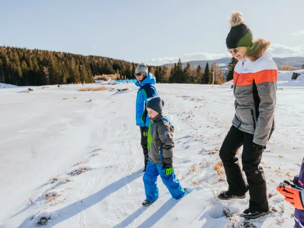 Ihr seht eine Familie beim Winterwandern auf der Hebalm im Schilcherland.