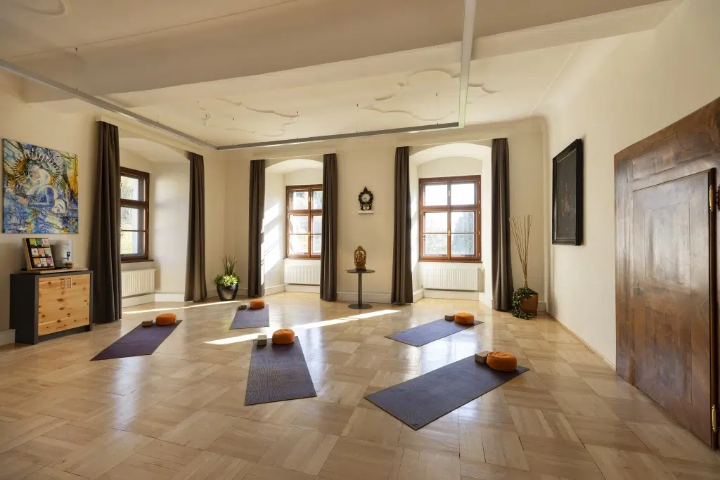 Ihr seht eine Frontansicht des Yoga Raumes im Kapitelsaal des JUFA Hotel Stift Gurk****. Der Ort für erholsamen Thermen- und entspannten Wellnessurlaub für die ganze Familie.