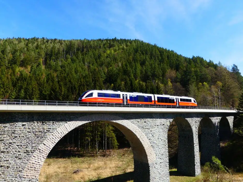 Sie sehen ein Bild von einem Zug der ÖBB auf einem Bahnviadukt in Aspang-Markt in Niederösterreich.