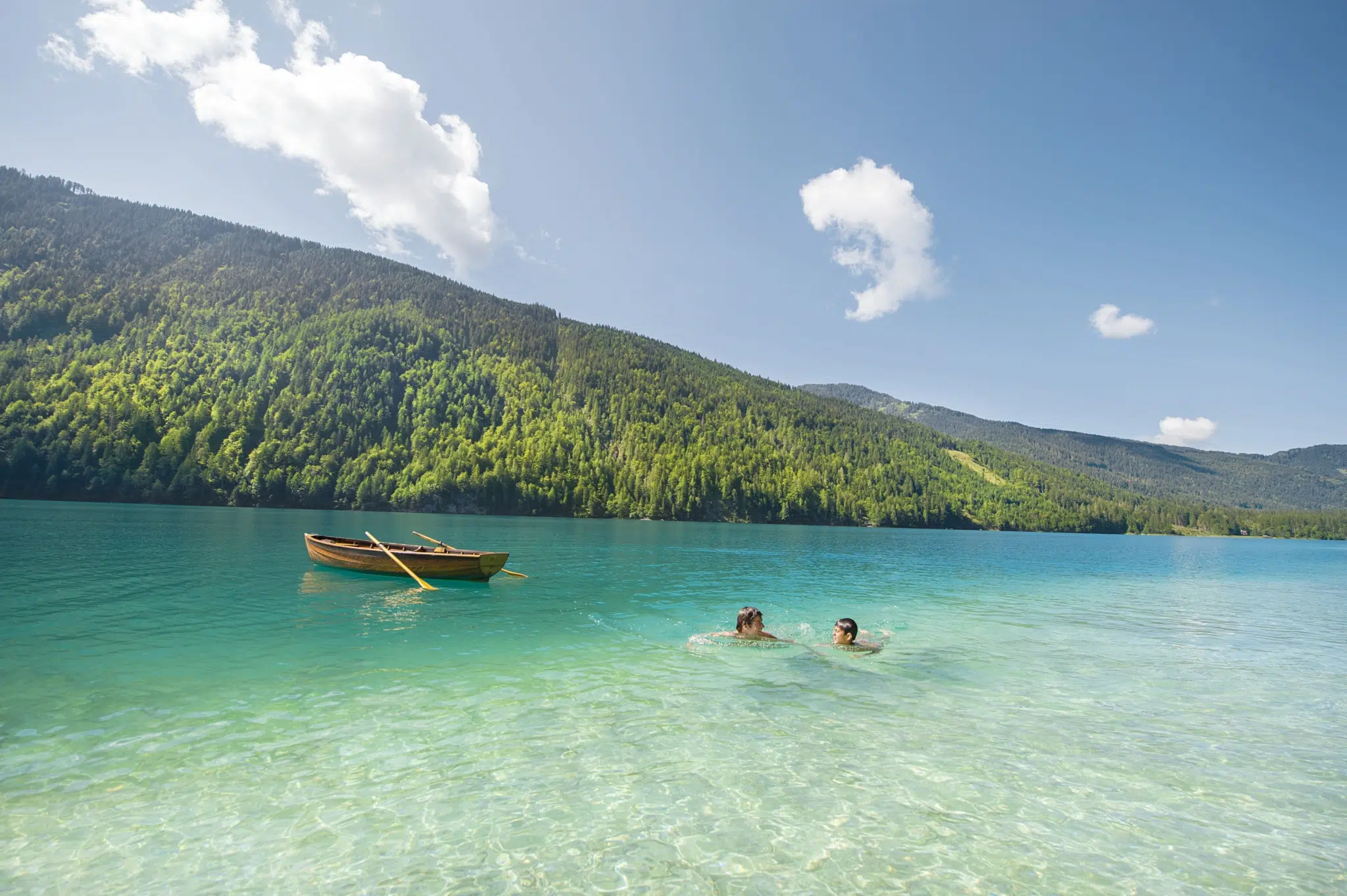 Ihr seht zwei Kinder beim Baden im Weissensee im Sommer.