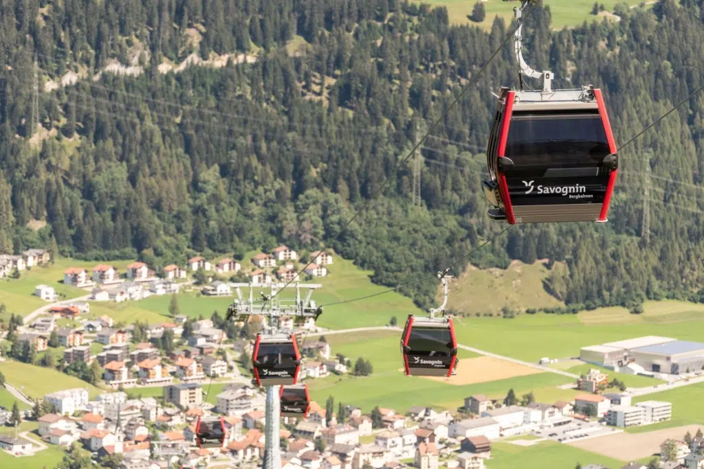 Ihr seht die Gondeln der Bergbahnen in Savognin über der Landschaft