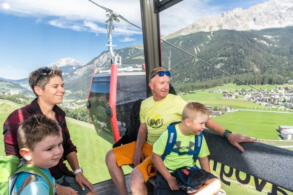 Ihr seht eine Familie, die in einer Gondel der Berbahnen Savognin die Aussicht geniesst