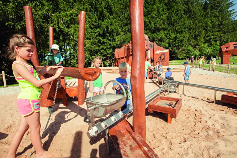 Ihr seht Kinder beim Spielen am Spielplatz bei der Alpsee Bergwelt im Allgäu.