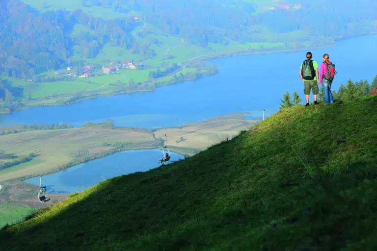 Ihr seht zwei Personen bei einer Wanderung in der Alpsee Bergwelt im Allgäu.