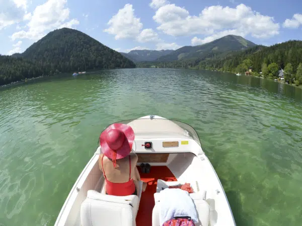 Ihr seht eine Frau beim Bootfahren auf dem Erlaufsee im Mariazellerland. Der Ort für tollen Sommerurlaub an schönen Seen für die ganze Familie.