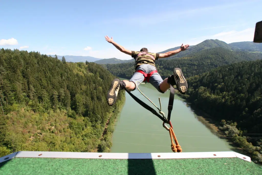 Ein Mann beim Bungy-Sprung von der Jauntalbrücke. JUFA Hotels bieten erholsamen Familienurlaub und einen unvergesslichen Winter- und Wanderurlaub.