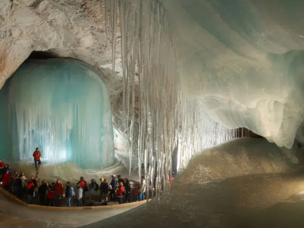 Ihr seht eine Führung durch die Höhle in der Eisriesenwelt Werfen mit mehreren Personen.