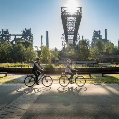 Ihr seht zwei Radfahrer auf einem Radweg in NRW.