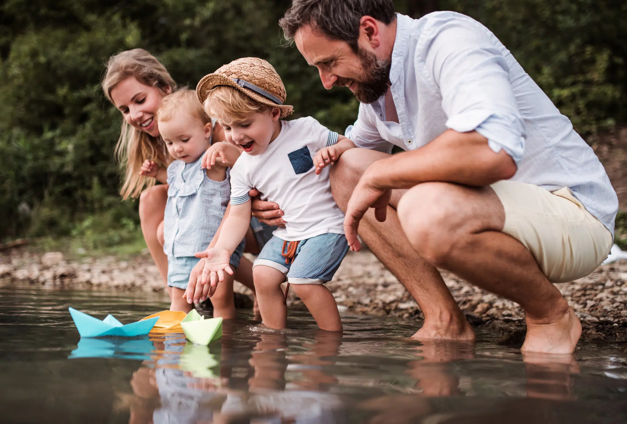 Sie sehen eine Familie am See. JUFA Hotels bietet tollen Sommerurlaub an schönen Seen für die ganze Familie.