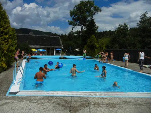 Ihr seht Kinder, die einen heißen Sommertag im Freibad Reith in Annaberg genießen. JUFA Hotels bietet kinderfreundlichen und erlebnisreichen Urlaub für die ganze Familie.