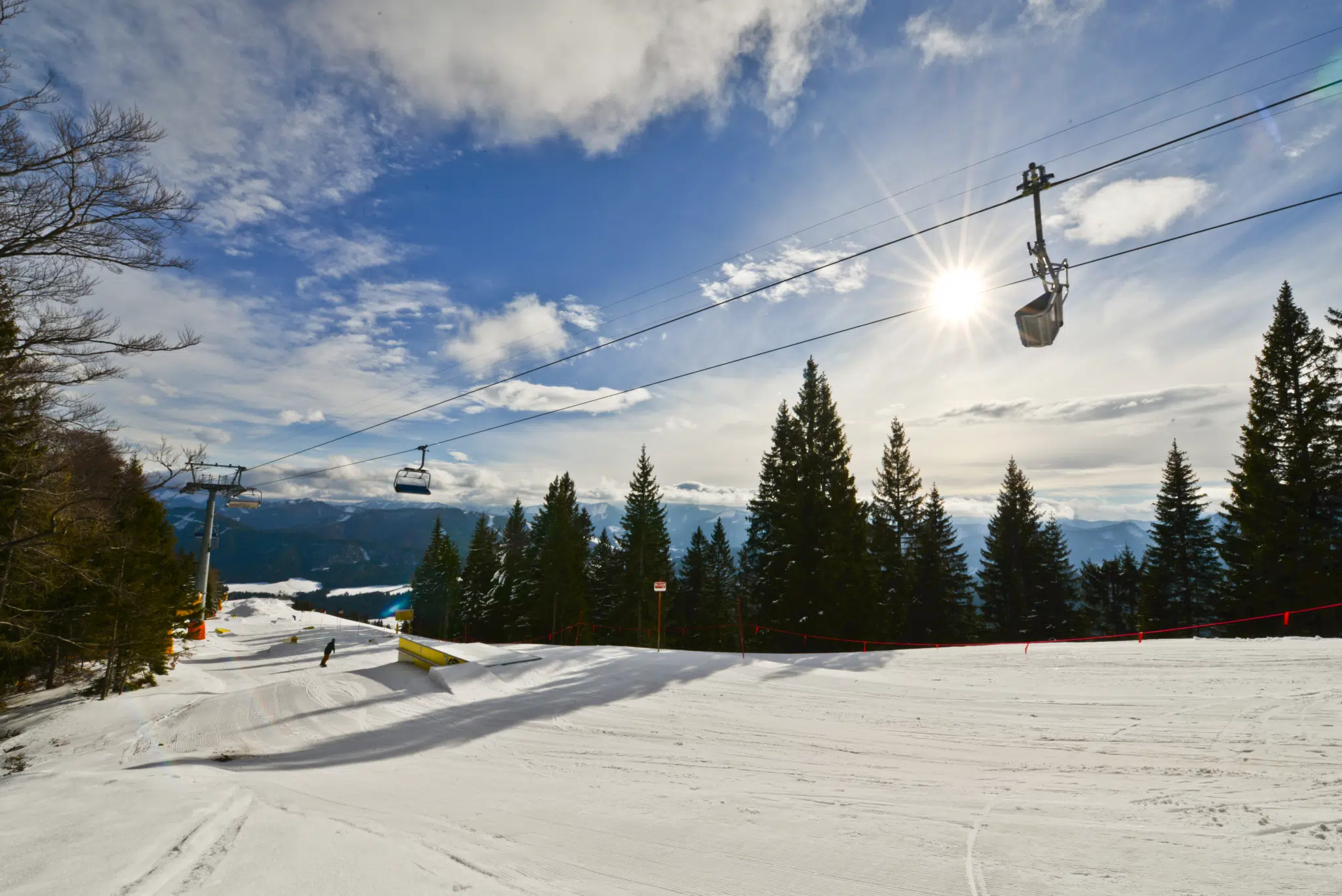 Ihr seht einen Lift vom Skigebiet Gemeindealpe mit verschneiter Piste im Mariazellerland.