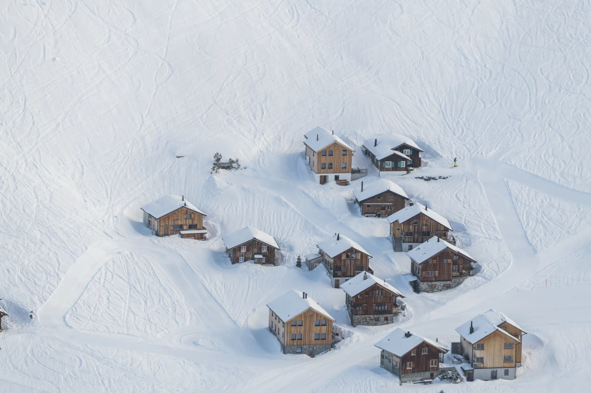 Ihr seht ein paar Häuser von Malbun aus der Vogelperspektive mit viel Schnee im Winter. JUFA Hotels bietet erholsamen Familienurlaub und einen unvergesslichen Winterurlaub.