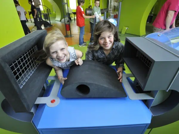 Ihr seht zwei Kinder bei Experimenten im Science Center im Haus der Natur in Salzburg.