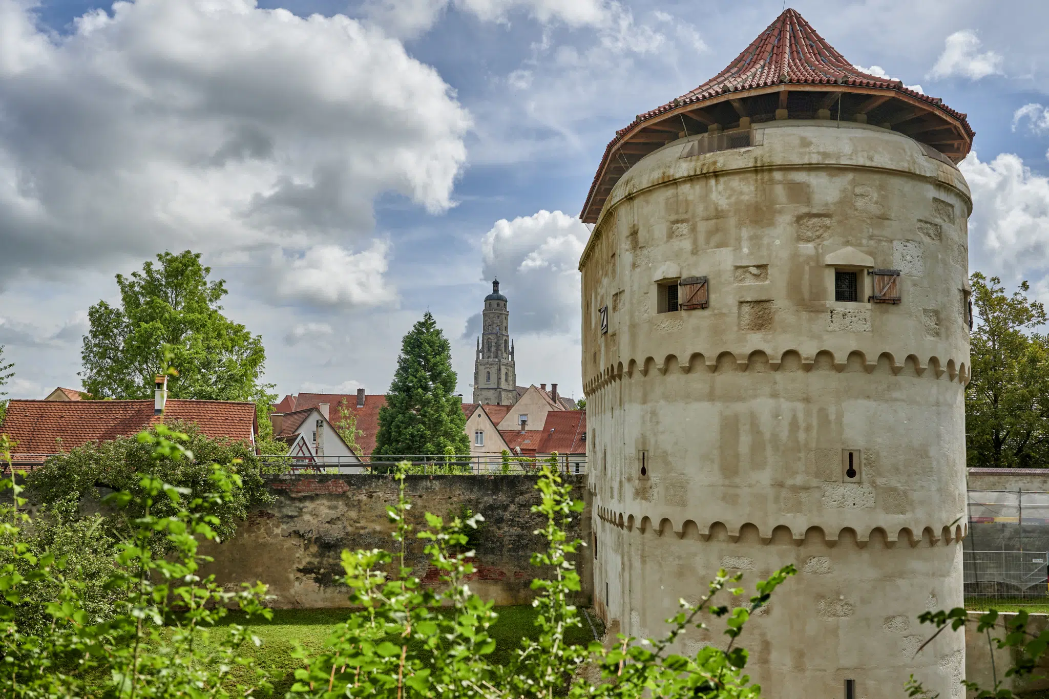 Ihr seht den Kirchturm Daniel in Nördlingen mit der Stadtmauer.