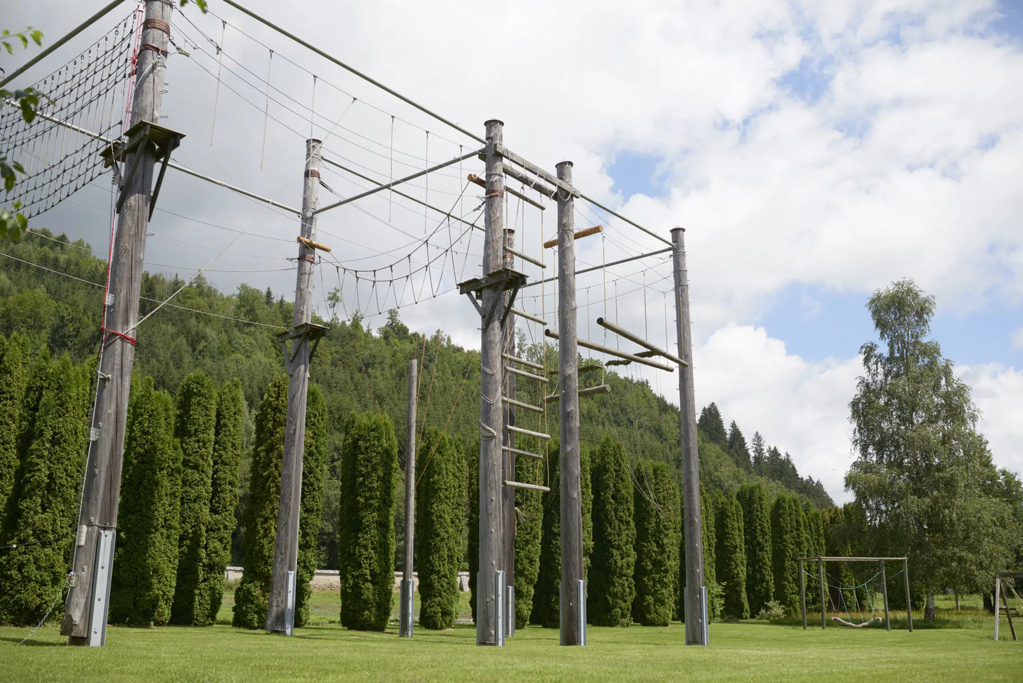 Sie sehen den Klettergarten im JUFA Hotel Stift Gurk im Sommer. JUFA Hotels bietet Ihnen den Ort für erlebnisreichen Natururlaub für die ganze Familie.