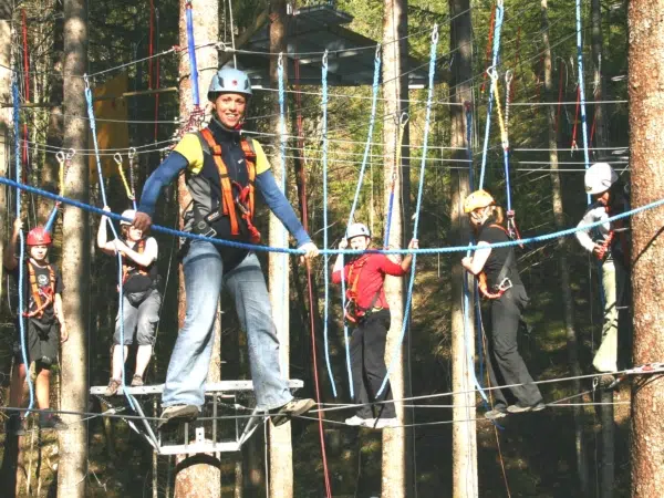 Ihr seht den Hochseil-Kletterpark Omunduntn mit Kindern. JUFA Hotels bietet erlebnisreiche und kreative Schulprojektwochen in abwechslungsreichen Regionen.