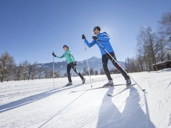 Ihr seht zwei Personen beim Langlaufen im Winter in Zell am See-Kaprun.