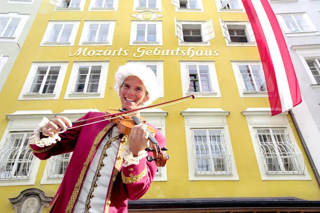 Sie sehen ein Bild von einem Mozart Darsteller vor dem Geburtshaus von Wolfgang Amadeus Mozart in der Salzburger Innenstadt.