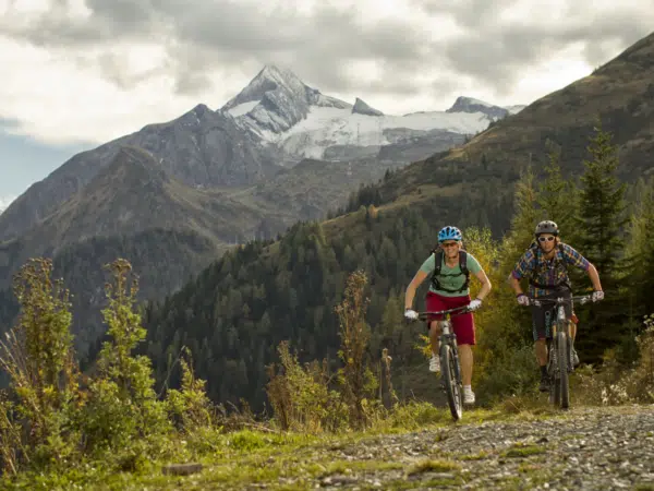 Ihr seht ein Paar beim Mountainbiken auf dem Maiskogel in Zell am See-Kaprun.