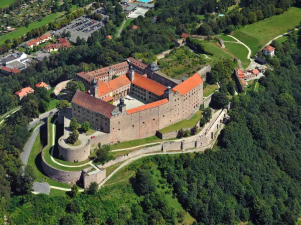 Ihr seht eine Luftaufnahme der Festung Plassenburg in Kulmbach. JUFA Hotels bietet kinderfreundlichen und erlebnisreichen Urlaub für die ganze Familie.